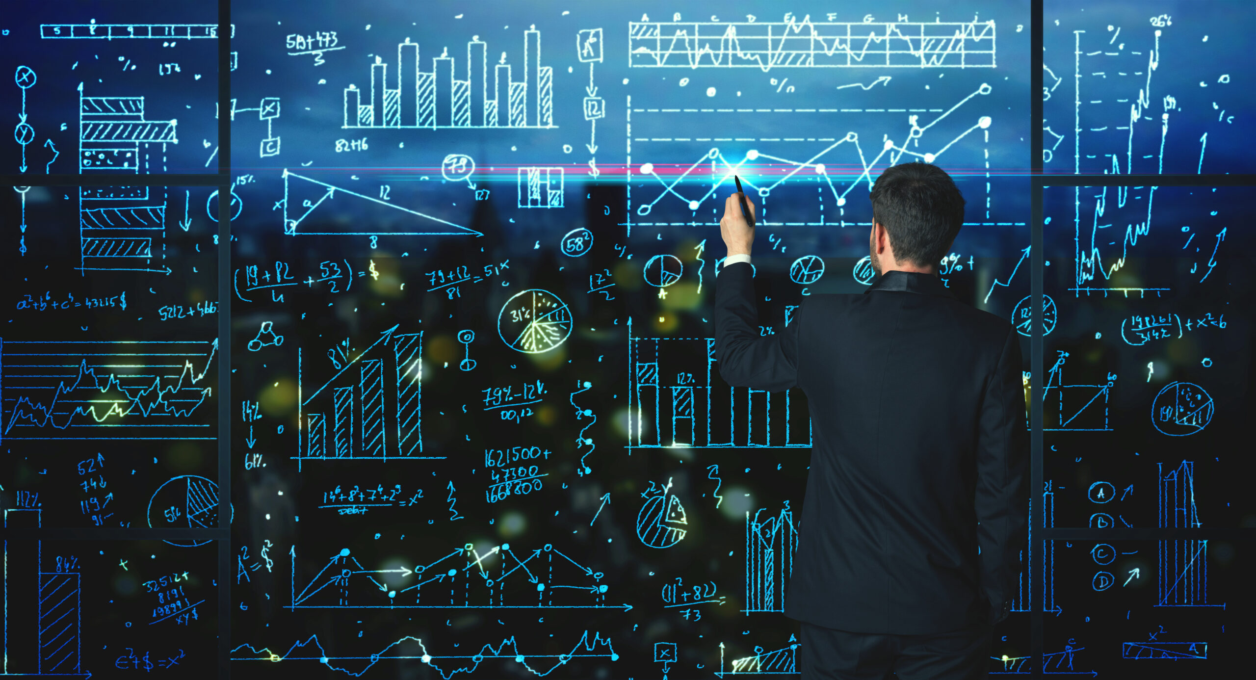 Businessman drawing business statistics on glass wall